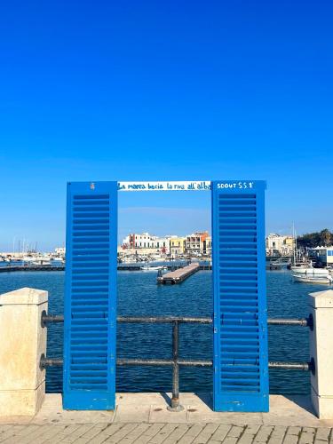 a pair of blue doors on the side of a body of water at Orchidea in Bari