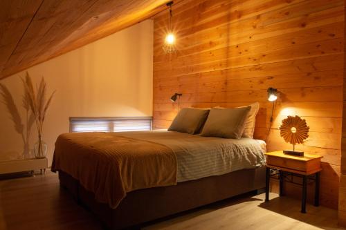 a bedroom with a bed and a wooden wall at De Boalder in Hardenberg