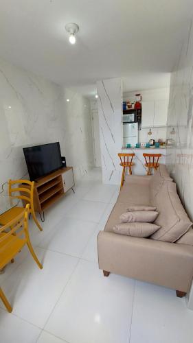 uma sala de estar com um sofá e uma televisão em Apto Familiar em Aracaju