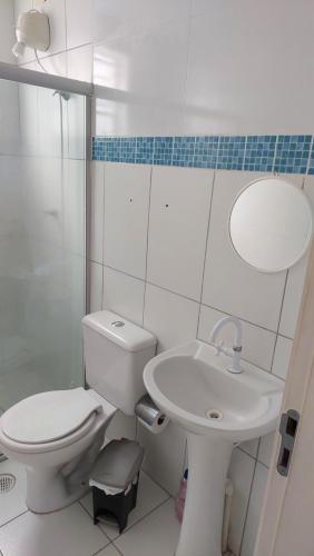 a white bathroom with a toilet and a sink at Apto Familiar in Aracaju