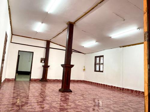 an empty room with a large pole in the middle at ameliehouse​ in Luang Prabang