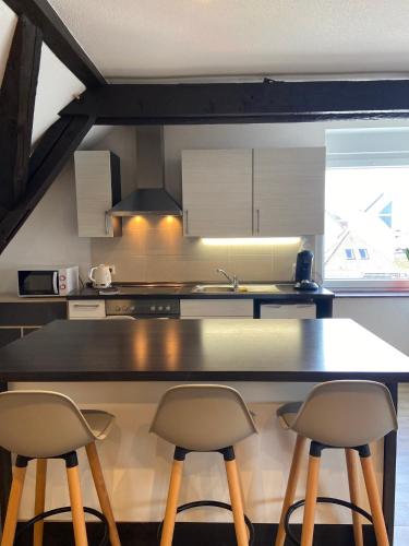 une cuisine avec un comptoir et deux tabourets dans l'établissement Bel appartement 2 pièces, à Soufflenheim