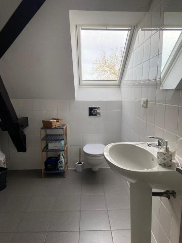 La salle de bains est pourvue d'un lavabo et de toilettes avec une fenêtre. dans l'établissement Bel appartement 2 pièces, à Soufflenheim