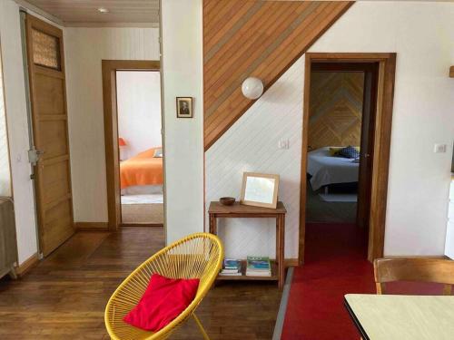 a room with a chair and a bedroom with a bed at Villanelle maison en centre hyper calme et au vert in Limoges