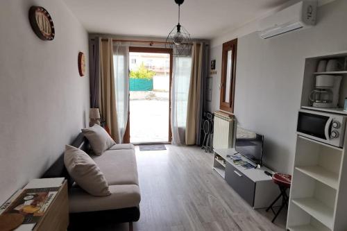 un salon avec un canapé et une télévision dans l'établissement Appartement proche plages et commerces, à La Ciotat