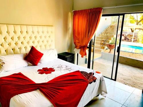 Eeufees Guesthouse في بلومفونتين: غرفة نوم عليها سرير وعليها ثوب احمر