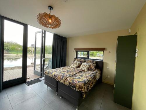 a bedroom with a bed and a large window at Casitas Wijchen - Nijmegen in Wijchen