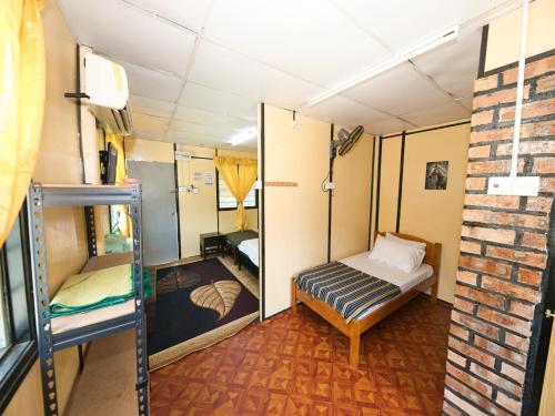 um pequeno quarto com uma cama e uma parede de tijolos em OYO 90960 Rajawali D'cabin Chalet Roomstay em Kuala Terengganu