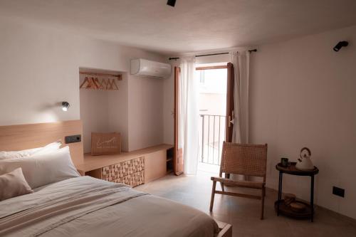 チェファルにあるLa Petì Small Luxury House Cefalùのベッドと椅子と窓のある寝室