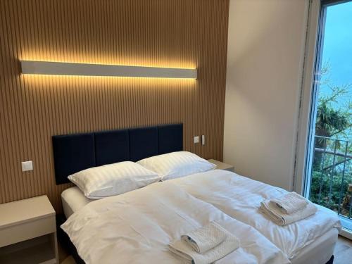 una camera da letto con un grande letto bianco con asciugamani di Lake Dream a Brissago
