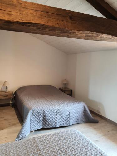 a bedroom with a bed and a wooden ceiling at La Lauriére in Treize-Vents