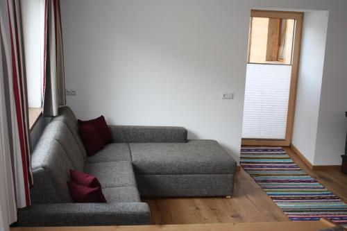 a living room with a couch and a window at Ferienhaus & -wohnung Flatscher in Waidring