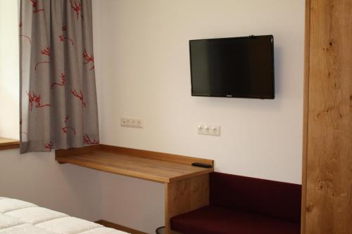 a room with a tv on a wall with a shelf at Ferienhaus & -wohnung Flatscher in Waidring