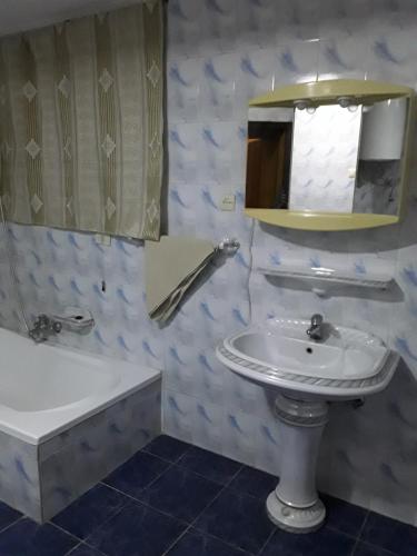 a bathroom with a sink and a mirror and a tub at Addis Joy Guesthouse in Addis Ababa
