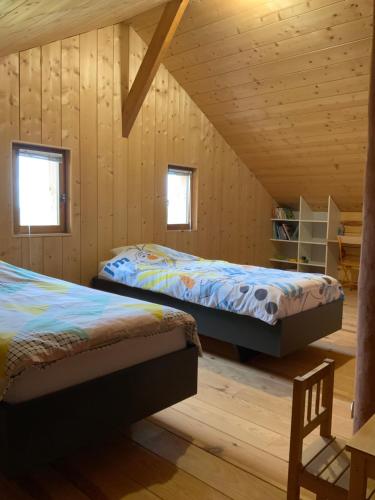 deux lits dans une chambre aux murs en bois dans l'établissement Maison bois, proche Sarlat, à Domme