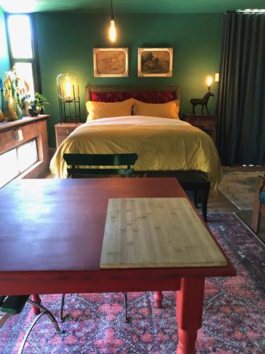 a bedroom with a bed and a wooden table at Container stories in Bloemfontein