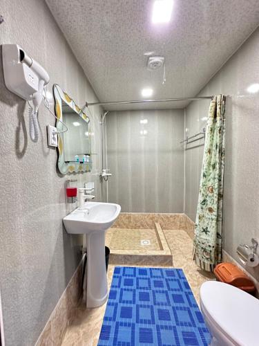 y baño con lavabo, aseo y espejo. en Gold Khiva en Khiva