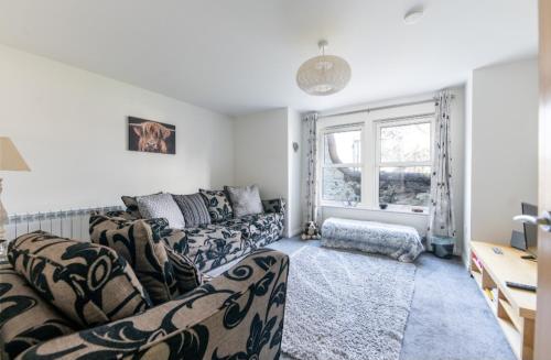 a living room with two couches and a window at No.3 On The Square in Beauly