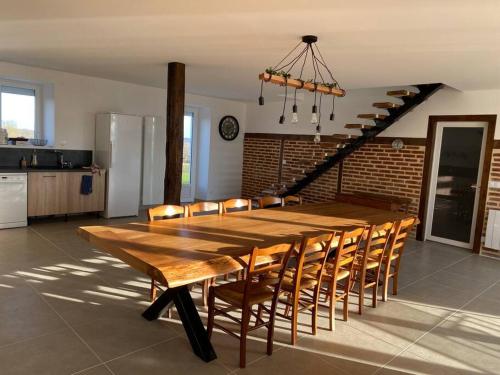 - une grande table et des chaises en bois dans la cuisine dans l'établissement Longère à la campagne rénovée à neuf, à Le Lys-Saint-Georges