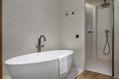 a white bath tub in a bathroom with a shower at AC Hotel Gava Mar in Gavà