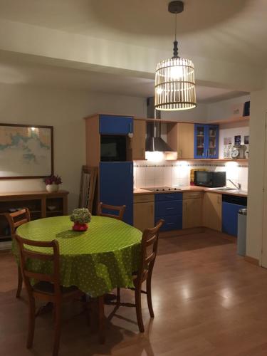 une cuisine avec une table et un tissu de table vert dans l'établissement Sainte-Marine, Appartement cosy rez-de-jardin à 150m de la plage, à Combrit