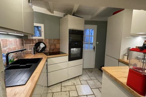 a kitchen with a sink and a stove top oven at Maison de charme avec piscine in Vignoux-sous-les-Aix