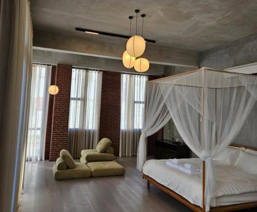 豐盛港的住宿－BASED - Mersing，一间卧室配有一张天蓬床和一把椅子
