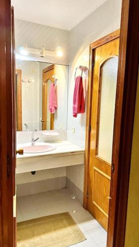 un baño con lavabo y espejo en Almerimar Seaside Flat, en El Ejido