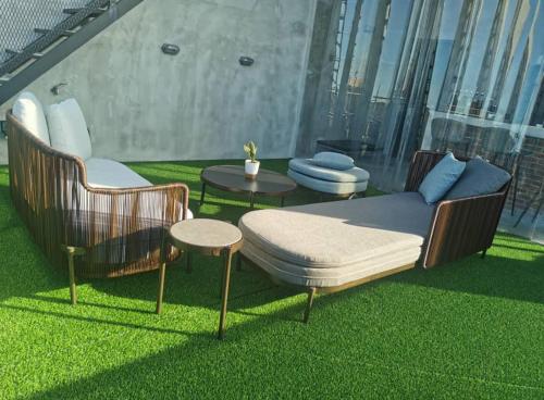 a patio with two chairs and a table on the grass at BASED - Mersing in Mersing