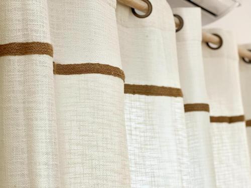 a close up of white curtains with brown at "Calm Joy & J" - Family in Ermoupoli
