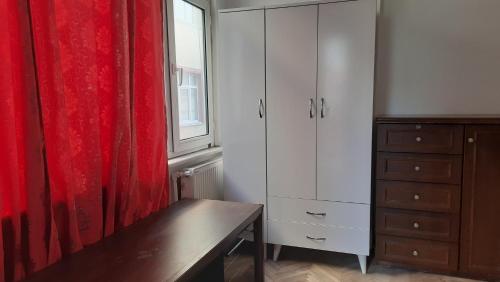 um quarto com uma cómoda e uma cortina vermelha em Şirinevler Guest house em Istambul