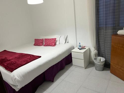 a bedroom with a bed with red pillows on it at Habitación por días in Catarroja