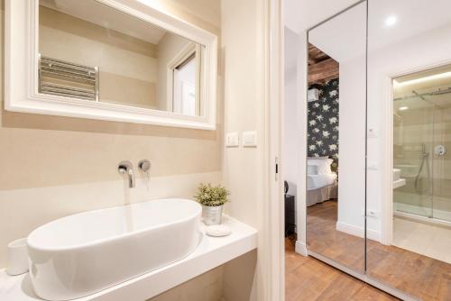 a white bathroom with a sink and a shower at i Fiori de' Mario Suites in Rome