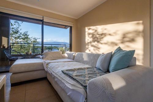 ein weißes Sofa im Wohnzimmer mit einem großen Fenster in der Unterkunft Andes Vista tu lugar en Mendoza in Godoy Cruz