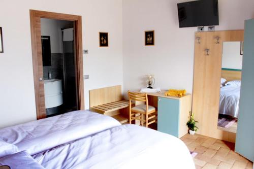 1 dormitorio con 1 cama y escritorio con TV en Agriturismo Il Moro, en Angolo Terme