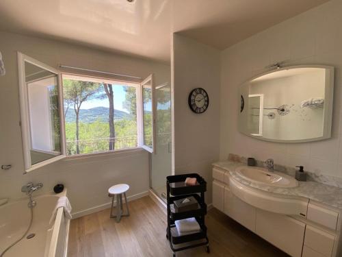 baño con lavabo, espejo y ventana en Une Pause en Provence, en Le Beausset