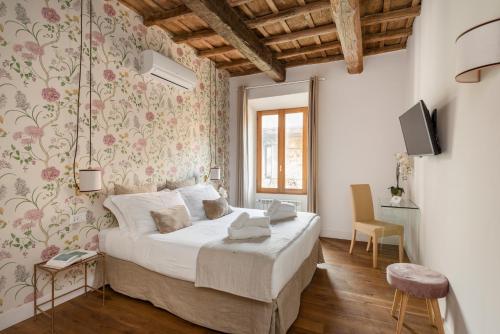 Un dormitorio con una cama y un televisor. en i Fiori de' Mario Suites, en Roma