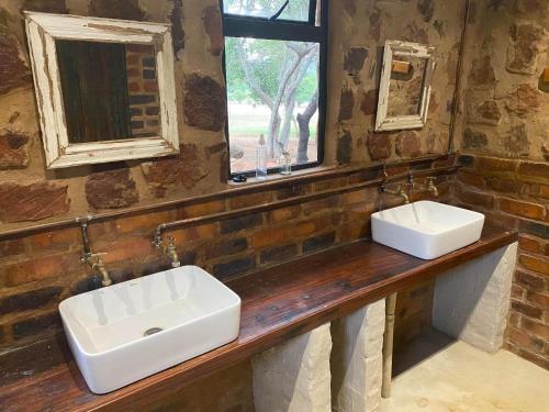 two sinks on a counter in a bathroom with a window at Soetvlei Tented Farm Camp in Magaliesburg