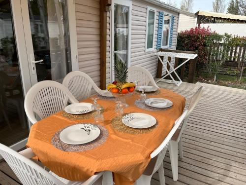- une table avec des assiettes et des bols de fruits sur une terrasse couverte dans l'établissement Le CHRISCERO (C118), à Sigean