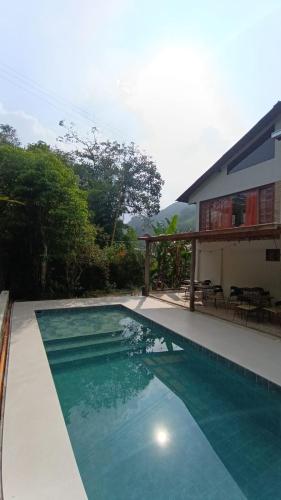 a swimming pool in front of a house at Hotel Boutique Albania in Otanche