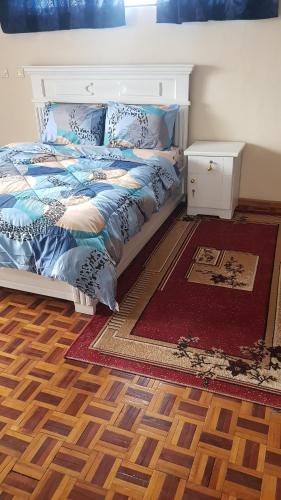 a bedroom with a bed and a rug at Addis Joy Guesthouse in Addis Ababa