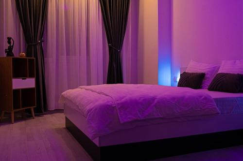 a purple bedroom with a bed with purple lighting at Best Residence Rin Grand Hotel in Bucharest