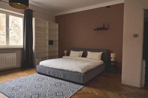 een slaapkamer met een bed en een groot raam bij Home you will love - in the green heart of Warsaw in Warschau
