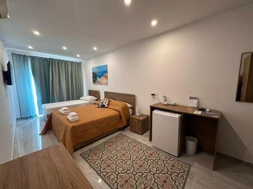 a hotel room with a bed and a desk at La Bella Guesthouse in St Julian's