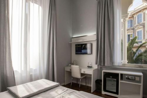 a bedroom with a desk and a bed and a window at Relais Villa Coppedè in Rome