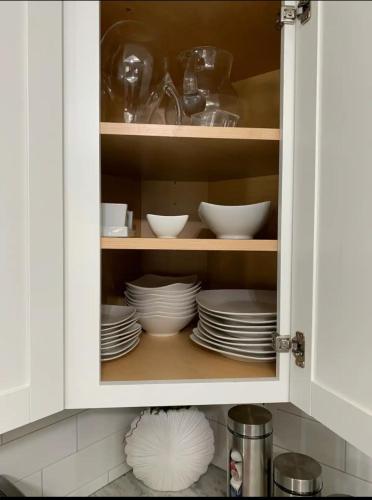 a cabinet with plates and bowls in it at Placeforus in Brooklyn