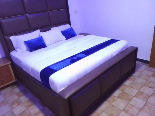 a large bed with blue pillows in a bedroom at Blue Moon Hotel Victoria Island in Lagos