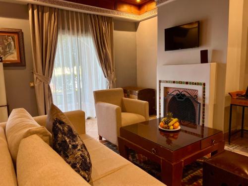 a living room with a couch and a fireplace at Pavillon du Golf -Palmeraie suites in Marrakesh