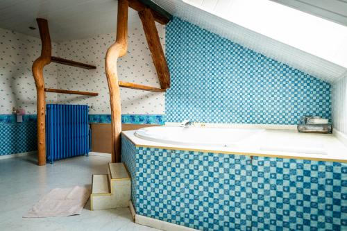 a blue and white bathroom with a bath tub at Gite des Rousses d'Amont - 15 personnes in Les Rousses