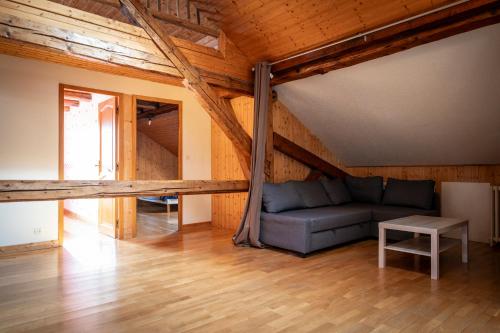 a living room with a couch in a attic at Gite des Rousses d'Amont - 15 personnes in Les Rousses